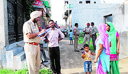 Police officials investigate the spot where a woman was brutally killed by her son in the Majitha road area in Amritsar on Friday
