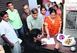 Residents throng a kiosk set up by the UT Administration to buy onions and potatoes at reasonable prices in Sector 46, Chandigarh, on Friday. 