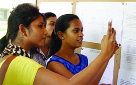 Delhi University aspirants check their names in the list at Miranda College, North Campus, on Friday.