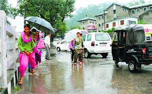 People pass through a waterlogged road in Mandi on Friday