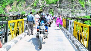 Roshani Sharma crosses Victoria Bridge, Mandi, enroute Leh, on Friday. 