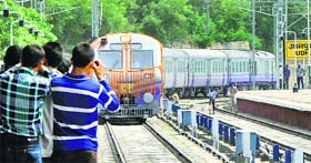 People take photo of the train as it reaches the Udhampur railway station carrying schoolchildren as its first passengers.