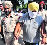 Accused Jasveer Singh (face covered) being produced in district courts, Mohali, on Saturday.