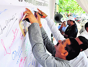 Congress state president Kishore Upadhyay takes part in a signature campaign in Dehradun on Saturday. 