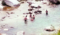 Tourists enjoy right in the middle of the Neugal river in Palampur on Saturday