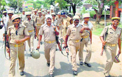 Police men patrol in Kanth town near Moradabad on Saturday. PTI