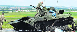 Ukrainian soldiers check a destroyed armoured vehicle at Slaviansk in eastern Ukraine on Saturday. Reuters