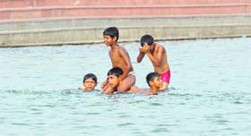 Endangering lives: Despite the ban, children swim in the Sector 42 lake in Chandigarh on Sunday.