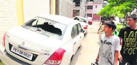 Children look at the damaged cars at EWS Colony in Bapu Dham.
