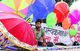 Colours of monsoon: A vendor, ready with a stock of umbrellas, waits for customers near Parade Ground in Dehradun on Sunday