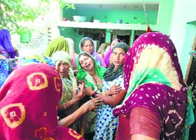 Relatives console Rani (centre), after her husband killed her father and brother in Karnal on Saturday