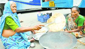Amarnath pilgrims from Gujarat prepare food near a registration counter in Jammu on Sunday.