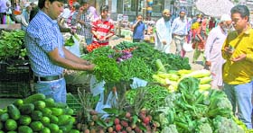 People buy vegetables from a vendor in Srinagar.