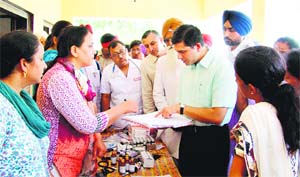 Rajat Aggarwal, Deputy Commissioner, Ludhiana, inspects records and medicines related to diarrhoea cases at a check-up camp. 