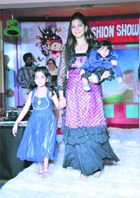 A woman sashays down the ramp with her children during a fashion show in Ludhiana on Sunday.