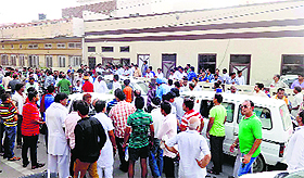 People gather around the house, where the couple died, in Abohar on Sunday; (right) the caved in roof of the house