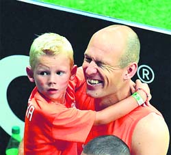 Netherlands' forward Arjen Robben celebrates with his son in his arms after a win over 