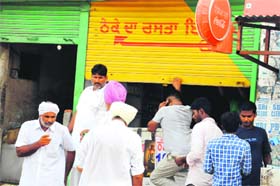 A vendor closes his liquor shop on a highway near the Rose Garden chowk in Bathinda on Monday.
