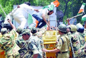 Congress workers try to jump over barricades during a demonstration near the Parliament House in New Delhi on Monday.