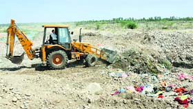 Solid waste being dumped in a trench by a JCB in Jammu