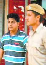 Jail inmate Dheeraj Batra being taken away by the police from the Mohali district courts on Monday