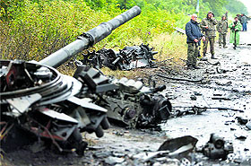 Ukrainian troops stand near destroyed military vehicles just outside the eastern Ukrainian town of Slaviansk on Monday.