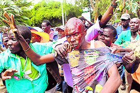 A supporter of Kenya's Opposition bleeds from a head injury while engaging with riot police in Nairobi on Monday.