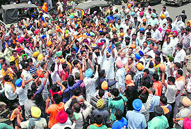 Mini-bus operators stage a protest outside the bus stand in Amritsar on Tuesday.