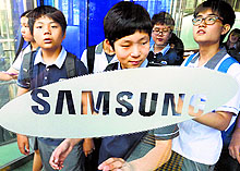 Students walk out of Samsung headquarters in Seoul on Monday. The company said on Tuesday its operating profit fell 24.5% in April-June quarter, its lowest in two years, due to slowing growth in smartphone business