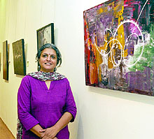 Artist Radha Kumar poses with her artworks during an exhibition Abstract Expressions at Lalit Kala Akademi, Mandi House in New Delhi on Tuesday