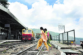 Girls walk over a narrow-gauge track at the railway station in Shimla on Tuesday.  Tribune photo: Amit Kanwar