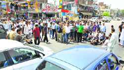 Residents of the Nai Basti area protest against unscheduled power cuts in Jammu on Wednesday. Tribune photo: Inderjeet Singh