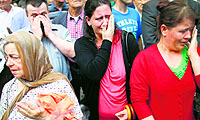 Bosnian women cry near a truck (not in pic) carrying 173 coffins of newly identified victims of the 1995 Srebrenica massacre in front of the presidential building in Sarajevo on Wednesday