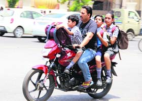 Risking their lives: A man with his children on a bike at Hanuman Chowk, Bathinda, on Thursday