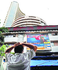 An investor watches the market reaction at the Bombay Stock Exchange in Mumbai on Thursday.