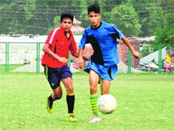Players vie for the ball during a match in the Nemidas Memorial District League at Pavilion Ground in Dehradun on Thursday. 