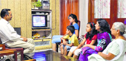 Rajeev Jain, secretary, Federation of Industrial and Commercial Undertaking, watches the telecast of the Budget speech along with his family in Ludhiana on Thursday. Photo: Inderjeet Verma