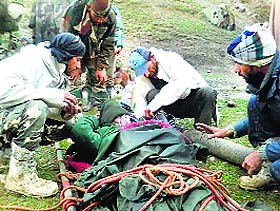 A mountain rescue team of the police helps a pilgrim in distress.