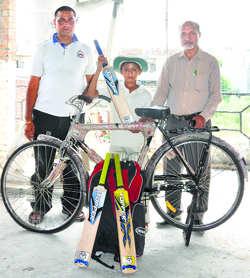 Lovjeet with the cricket kit and bicycle gifted to him by members of the Global Social Foundation in Ludhiana.