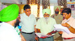 Principal Secretary, Administrative Reforms, C Rao (extreme right) checks documents at a Suvidha Kendra in Fatehgarh Sahib on Friday. A Tribune photograph