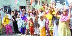 Wearing electric wires around their neck, a group of Congress workers protests unscheduled power cuts in Sangrur on Saturday. Tribune photo