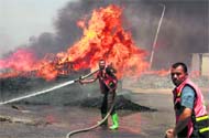 A Palestinian fire-fighter tries to extinguish a fire