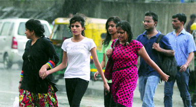 People caught in the rains at Connaught place in New Delhi on Sunday. 