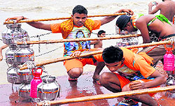 Kanwariyas fetch Ganga water from Har-ki-Pauri on the first day of Shravan Kanwar in Haridwar on Sunday