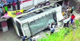 An HRTC bus that fell down from the road at Dhiarighat village, near Solan, on Sunday.