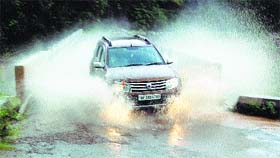 A motorist drives through a water logged road during heavy rain in Dharamsala on Sunday.