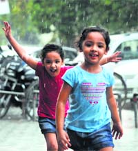 Children enjoy the sudden showers that gave some respite from the extreme hot weather in Ludhiana on Sunday.