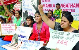 Activists of Pragatisheel Mahila Sangthan hold placards as they raise slogans during a demonstration against violence on women at Jantar Mantar in New Delhi on Monday
