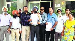 AAP leaders show a copy of the memorandum they handed over to the MC officials regarding problems in water supply in Jalandhar on Monday. Photo: Sarabjit Singh