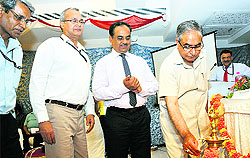 Agriculture Minister Ghulam Hassan Mir lights a lamp during the NABARD foundation day function in Jammu on Monday